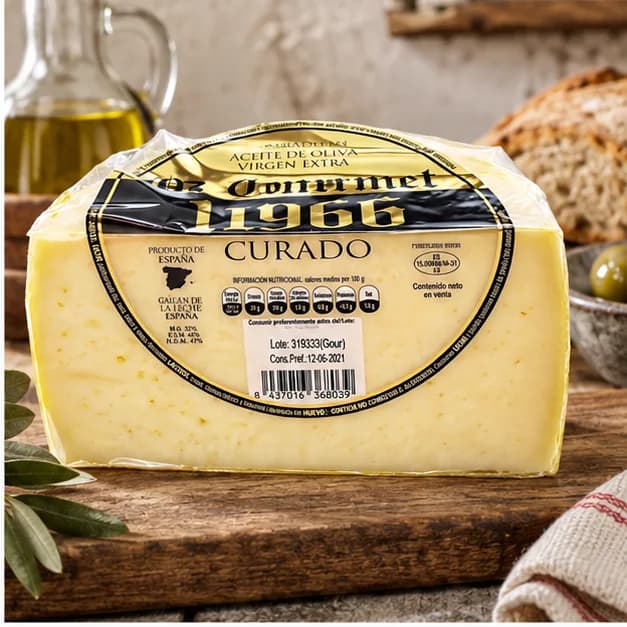 Queso Curado 1966 Gourmet Oro, en una mesa de madera